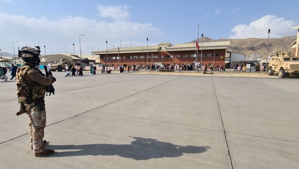 Afghan evacuees queue before boarding Italy's military aircraft C130J during the evacuation at Kabul's airport, Afghanistan, August 22, 2021. Italian Ministry of Defence/Handout via REUTERS - Sputnik International