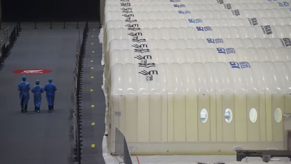 Medical workers walk past BGI's Huo-Yan (Fire Eye) laboratories set up inside an expo centre to test nucleic acid samples, following the coronavirus disease (COVID-19) outbreak in Nanjing, Jiangsu province, China July 28, 2021 - Sputnik International