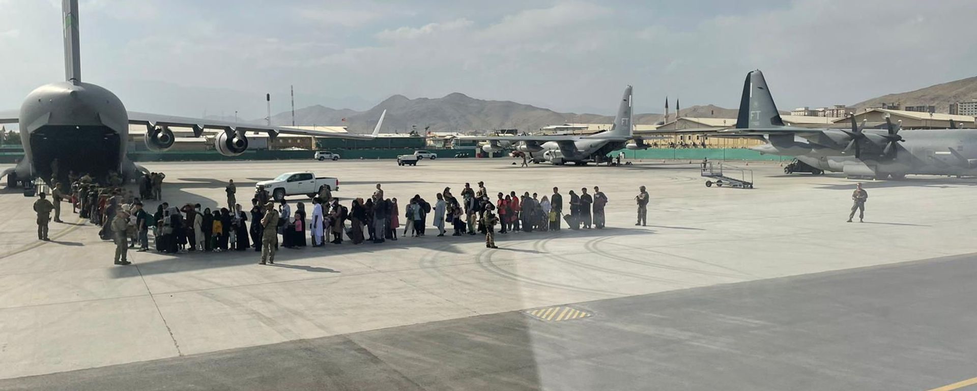 Afghan evacuees queue before boarding one of the last Italy's military aircraft C130J during evacuation at Kabul's airport, Afghanistan, August 27, 2021 Afghan evacuees queue before boarding one of the last Italy's military aircraft C130J during evacuation at Kabul's airport, Afghanistan, August 27, 2021 - Sputnik International, 1920, 14.10.2021