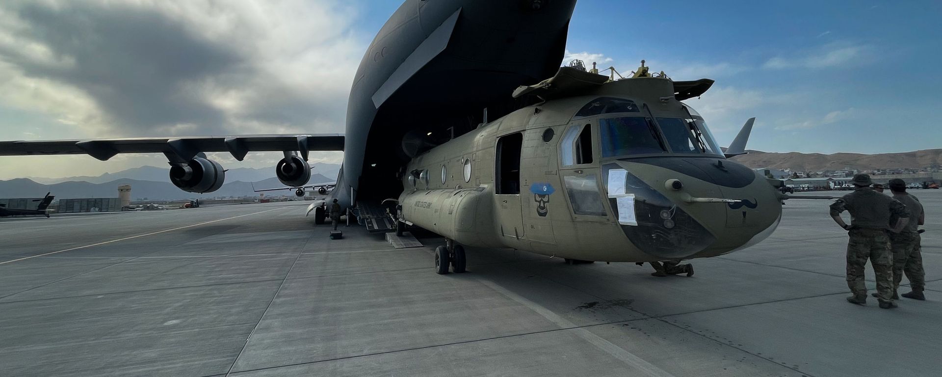 A CH-47 Chinook from the 82nd Combat Aviation Brigade, 82nd Airborne Division is loaded onto a U.S. Air Force C-17 Globemaster III at Hamid Karzai International Airport in Kabul, Afghanistan, August 28. The Chinook. is one of the pieces of equipment returning to the U.S. as the military mission in Afghanistan comes to an end. A CH-47 Chinook from the 82nd Combat Aviation Brigade, 82nd Airborne Division is loaded onto a U.S. Air Force C-17 Globemaster III at Hamid Karzai International Airport in Kabul, Afghanistan, August 28. The Chinook. is one of the pieces of equipment returning to the U.S. as the military mission in Afghanistan comes to an end. - Sputnik International, 1920, 30.08.2021