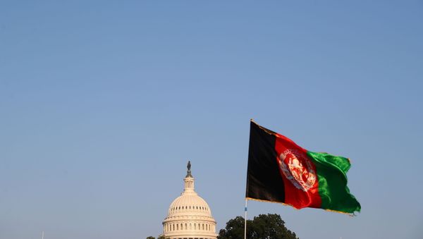 The dome of the U.S. Capitol is seen next to an Afghan flag as protesters take part in a demonstration challenging the transparency of the evacuation process from Kabul Airport, in Washington, U.S., August 28, 2021. - Sputnik International