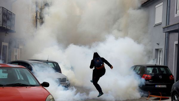 A demonstrator is covered in tear gas during a protest against the enthronement of Bishop Joanikije in Cetinje, Montenegro - Sputnik International