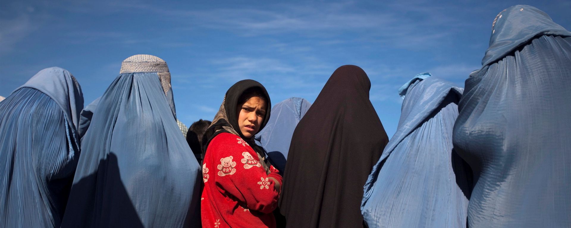 An Afghan girl stands among widows clad in burqas during a cash for work project by humanitarian organisation CARE International in Kabul An Afghan girl stands among widows clad in burqas during a cash for work project by humanitarian organisation CARE International in Kabul - Sputnik International, 1920, 07.09.2021