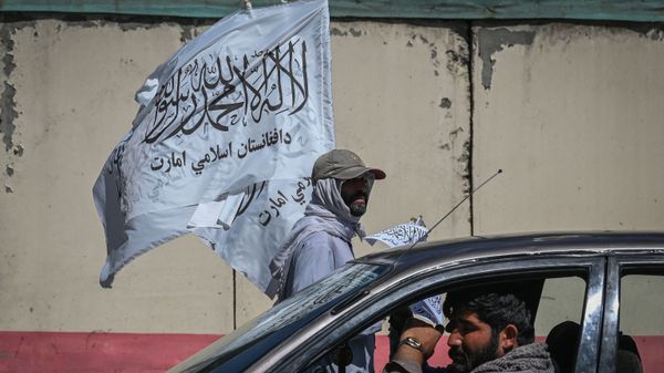 A mobile hawker carries Taliban flags as commuters make their way along a road in Kabul on September 5, 2021.  - Sputnik International