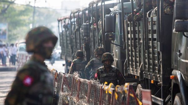 Soldiers stand next to military vehicles as people gather to protest against the military coup, in Yangon, Myanmar, February 15, 2021. - Sputnik International