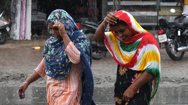 Women walk through a street during a heavy rain shower on the outskirts of Amritsar on September 3, 2021.  - Sputnik International
