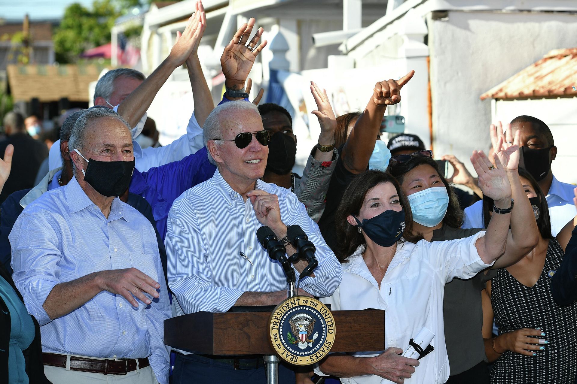 US Senator Chuck Schumer (L) and New York Governor Kathy Hochul (3rd R) wave to a child as US President Joe Biden speaks during a tour of a neighbourhood affected by Hurricane Ida in Queens, New York on September 7, 2021. - President Joe Biden headed Tuesday to storm-ravaged New York and New Jersey, just days after inspecting the damage caused by Hurricane Ida in Louisiana. Biden -- who is pushing a giant infrastructure spending bill, including major funding for the green economy -- argues that extreme weather across the United States this summer is a harbinger of worse climate change to come. - Sputnik International, 1920, 09.09.2021