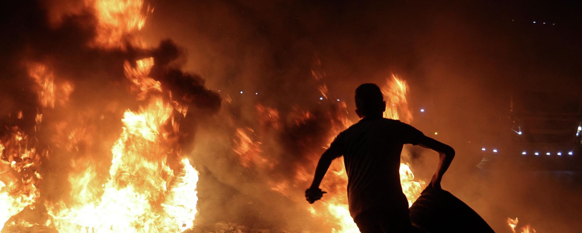 A Palestinian youth carries a tyre before setting it ablaze, during confrontations with Israeli security forces following a rally in support of Palestinian prisoners held in Israeli jails, at the Hawara checkpoint near the West Bank town of Nablus, on September 8, 2021. A Palestinian youth carries a tyre before setting it ablaze, during confrontations with Israeli security forces following a rally in support of Palestinian prisoners held in Israeli jails, at the Hawara checkpoint near the West Bank town of Nablus, on September 8, 2021. - Sputnik International, 1920, 25.12.2021