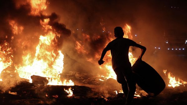 A Palestinian youth carries a tyre before setting it ablaze, during confrontations with Israeli security forces following a rally in support of Palestinian prisoners held in Israeli jails, at the Hawara checkpoint near the West Bank town of Nablus, on September 8, 2021. - Sputnik International
