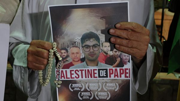 A man holds a poster depicting the Palestinian fugitives who broke out of a high-security jail, during a rally in the West bank town of Hebron on September 8, 2021 - Sputnik International