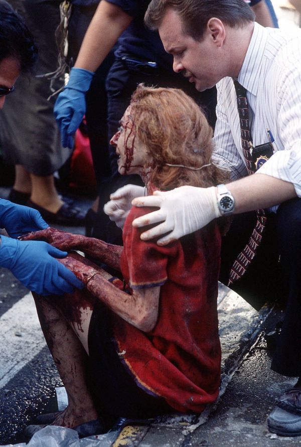 Emergency workers help a women after she was injured in the terrorist attack on the World Trade Center in New York, on 11 September 2001. - Sputnik International