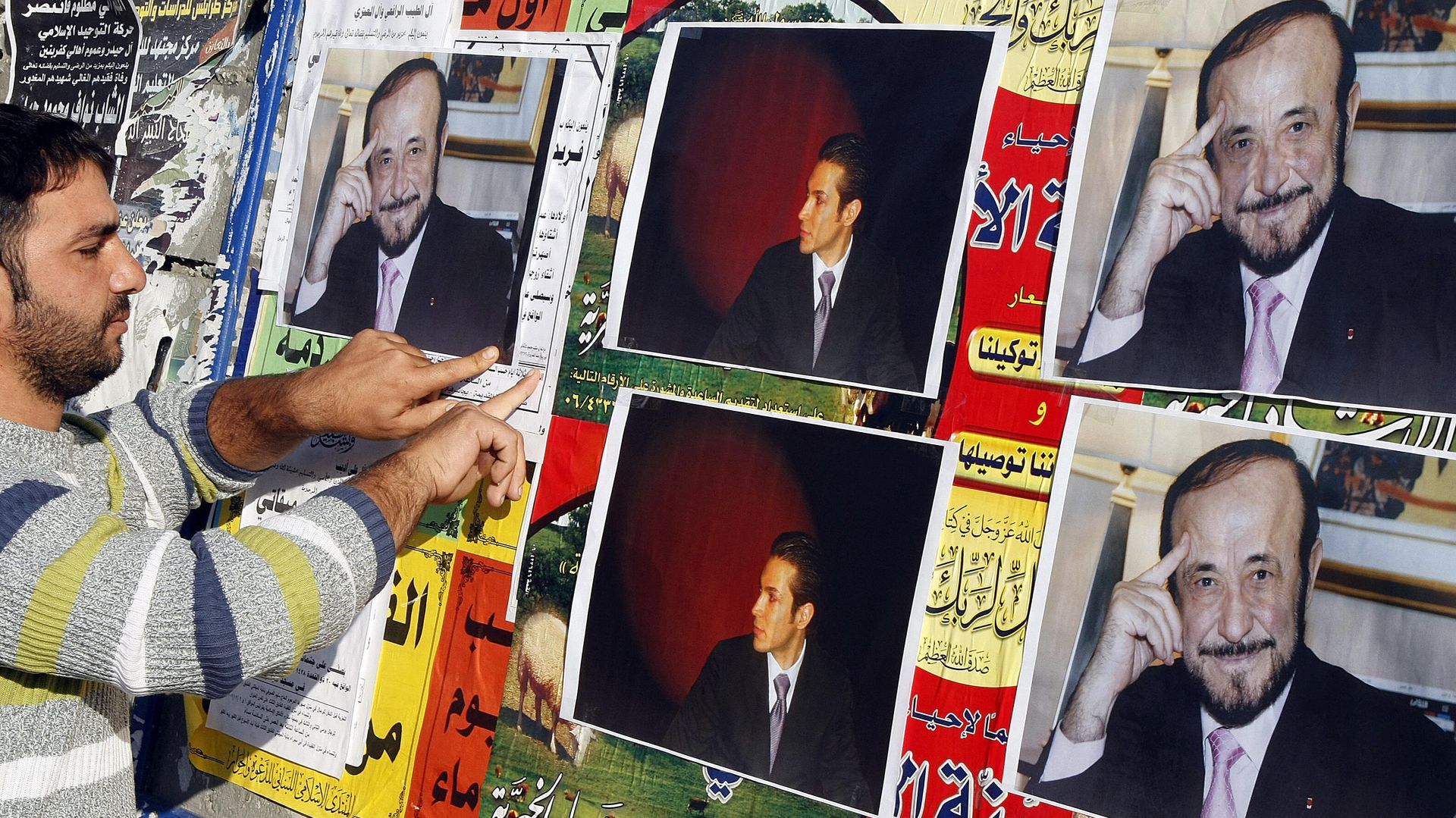 CORRECTING NAME OF RIFAATS SON: A member of the Alawite community pastes on a wall, in the northern Lebanese city of Tripoli 06 December 2007, pictures of Syrian opposition leader Rifaat al-Assad (R) and his son Ribal - Sputnik International, 1920, 09.09.2021