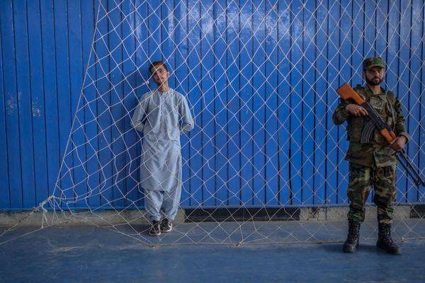 A young athlete (L) stands next to a Taliban fighter as others perform their skills during an event organised for the visit of the Taliban's director of physical education and sports, Bashir Ahmad Rustamzai (not pictured), at a gymnasium in Kabul on 14 September 2021. - Sputnik International
