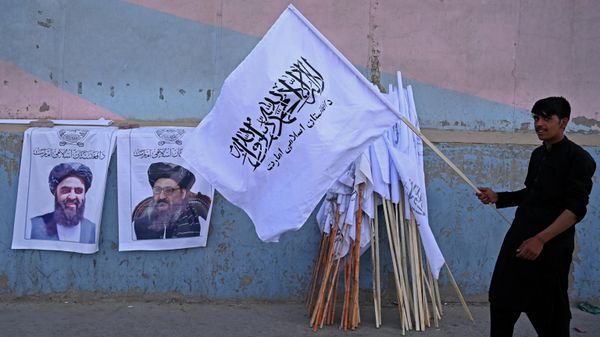 A vendor holds a Taliban flag next to the posters of Taliban leaders Mullah Abdul Ghani Baradar and Amir Khan Muttaqi (L) as he waits for customers along a street in Kabul on August 27, 2021, following the Taliban's military takeover of Afghanistan A vendor holds a Taliban flag next to the posters of Taliban leaders Mullah Abdul Ghani Baradar and Amir Khan Muttaqi (L) as he waits for customers along a street in Kabul on August 27, 2021, following the Taliban's military takeover of Afghanistan - Sputnik International