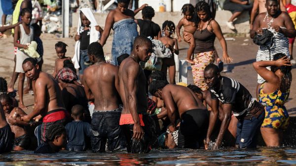 Asylum-seeking migrants wait to be processed under the international bridge in Del Rio, TX - Sputnik International