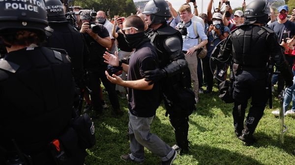 A police officer escorts a person during a rally in support of defendants being prosecuted in the January 6 attack on the U.S. Capitol, in Washington, D.C., U.S., September 18, 2021. REUTERS/Jonathan Ernst - Sputnik International