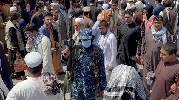 A member of Taliban security forces stands guard among crowds of people walking past in a street in Kabul, Afghanistan September 4, 2021.  - Sputnik International