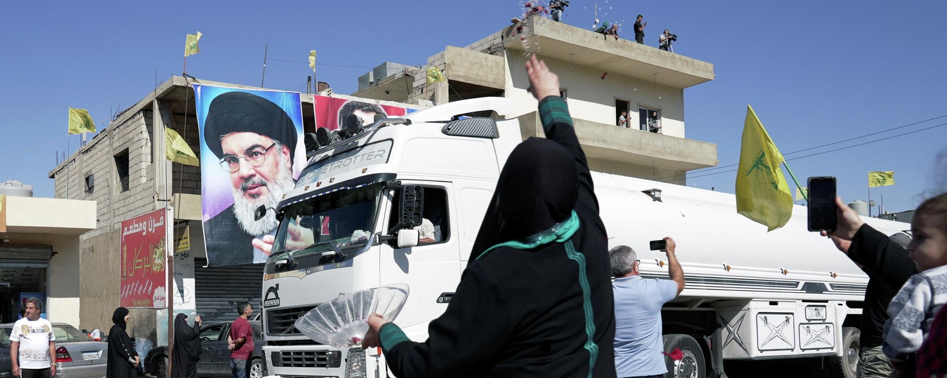 A woman throws flower petals and rice as a convoy of tanker trucks carrying Iranian fuel oil drive in al-Ain village, in northeastern Lebanon, September 16, 2021. - Sputnik International, 1920, 20.09.2021