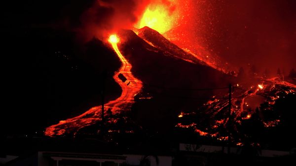 Lava flows next to a house following the eruption of a volcano in the Cumbre Vieja national park at El Paso, on the Canary Island of La Palma, September 19, 2021 - Sputnik International