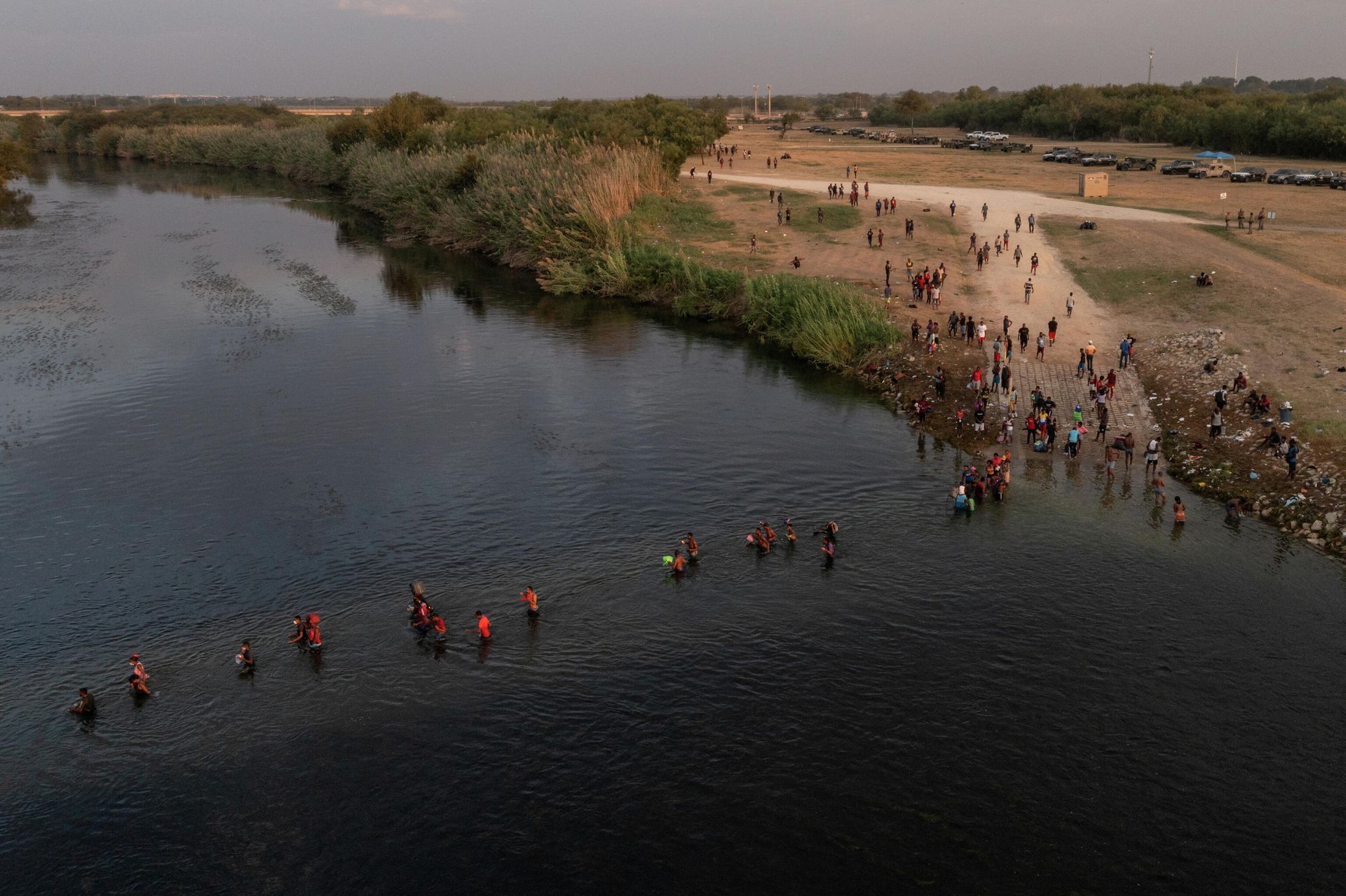 Migrants seeking refuge in United States cross the Rio Grande river, with bags and children in tow, back into Ciudad Acuna, Mexico from their camp in Del Rio, Texas, U.S. September 21, 2021.  - Sputnik International, 1920, 21.09.2021