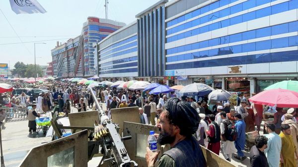 Members of Taliban security forces stand guard as crowds of people walk past in front of a money exchange market in Kabul, Afghanistan September 4, 2021 - Sputnik International