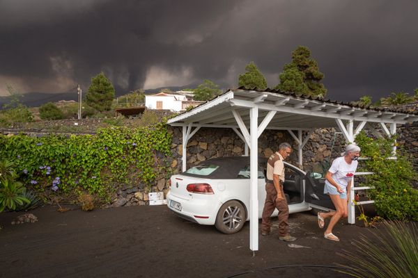 A rural agent helps a resident to collect her belongings from her home on 22 September 2021 in the Todoque neighbourhood in Los Llanos de Aridane. The creeping sea of lava flowing down the slopes of La Palma has destroyed 320 buildings covering more than 154 hectares of land, Europe's volcano observatory said. - Sputnik International