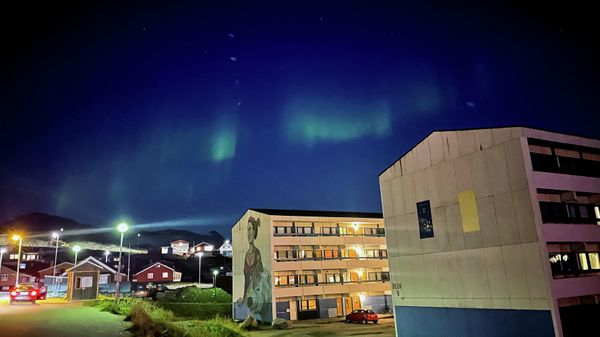 The Aurora Borealis (Northern Lights) is seen behind a building with social housings with a mural in Nuuk, Greenland, September 17, 2021. - Sputnik International