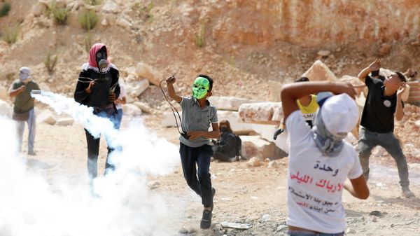 Palestinian demonstrators clash with Israeli forces during a protest in solidarity with prisoners following the escape of six Palestinian militants from an Israeli prison, in Beita, in the Israeli-occupied West Bank, September 10, 2021. - Sputnik International