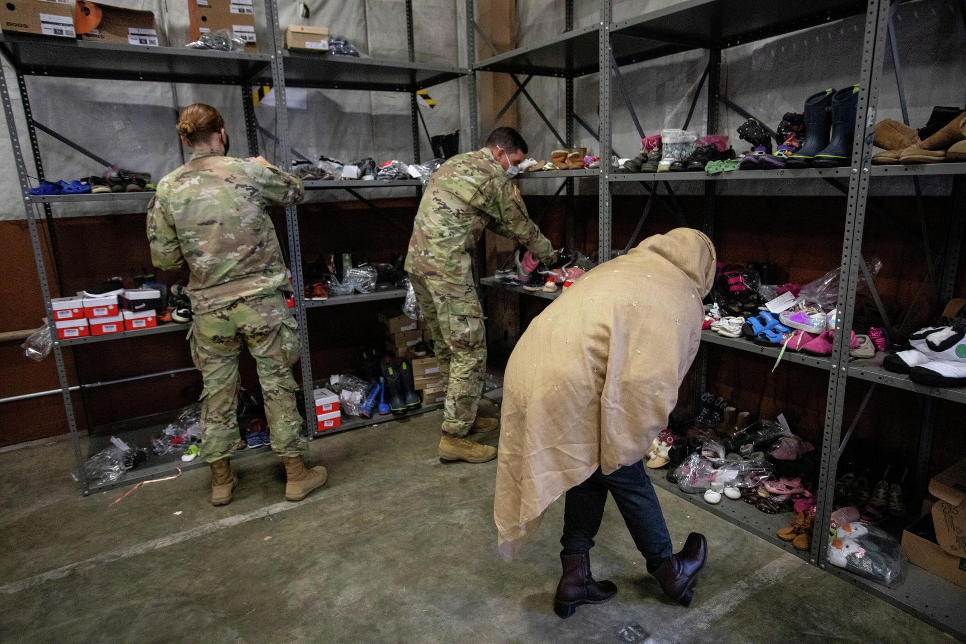 An Afghan refugee looks for donated shoes at the donation center at Fort McCoy U.S. Army base, in Wisconsin, U.S., September 30, 2021 - Sputnik International, 1920, 02.10.2021