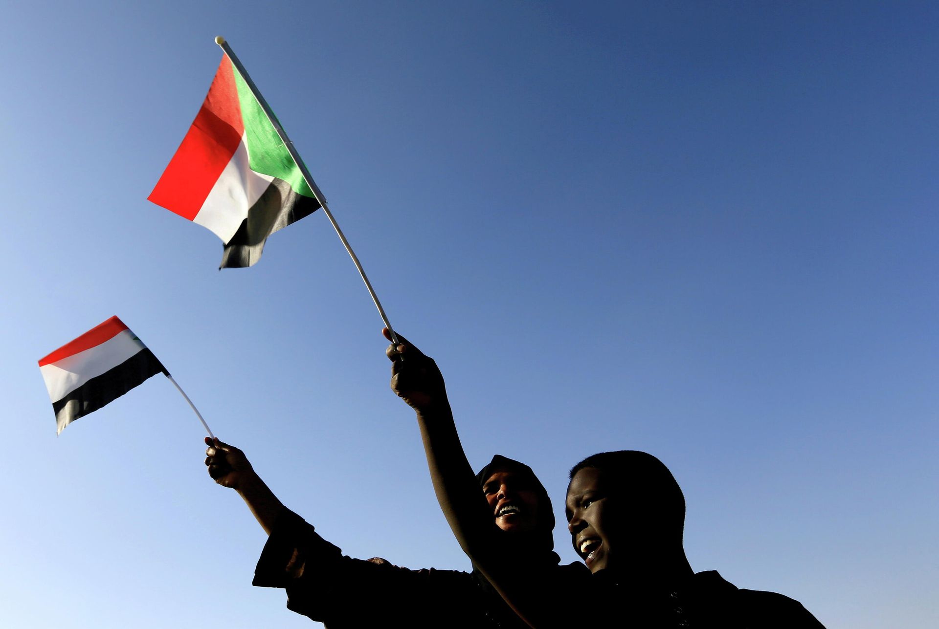 Sudanese wave their national flag as they gather at freedom square during the first anniversary of the start of the uprising that toppled long-time ruler Omar al-Bashir, in Khartoum, Sudan December 19, 2019. Sudanese wave their national flag as they gather at freedom square during the first anniversary of the start of the uprising that toppled long-time ruler Omar al-Bashir, in Khartoum, Sudan December 19, 2019. - Sputnik International, 1920, 25.10.2021