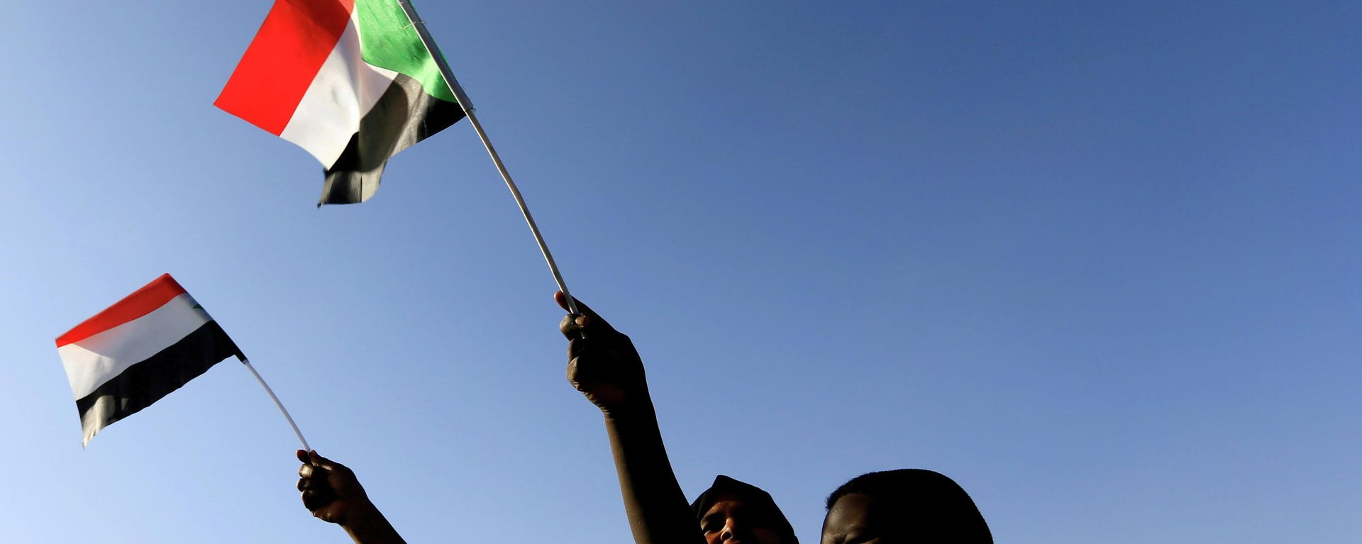 Sudanese wave their national flag as they gather at freedom square during the first anniversary of the start of the uprising that toppled long-time ruler Omar al-Bashir, in Khartoum, Sudan December 19, 2019.  - Sputnik International, 1920, 03.10.2021