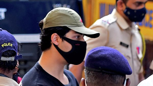 Bollywood actor Shah Rukh Khan's son Aryan Khan is being escorted by law enforcement officials outside the Narcotics Control Bureau (NCB) office after he was allegedly brought in for questioning along with others following a raid at a party on a cruise ship, in Mumbai on October 3, 2021. - Sputnik International