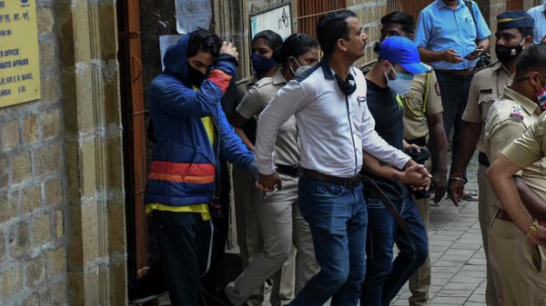Bollywood actor Shah Rukh Khan’s son Aryan Khan, left, is escorted by law enforcement officials outside the Narcotics Control Bureau (NCB) to appear before a court in Mumbai, India, Monday, Oct.4, 2021 - Sputnik International