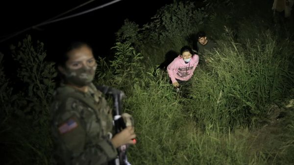 A Texas National Guard member illuminates a path as migrants cross over to the U.S., north of the Roma–Ciudad Miguel Aleman International Bridge, which spans the Rio Grande border with Mexico, in Roma, Texas, U.S. October 1, 2021. Picture taken October 1, 2021 - Sputnik International