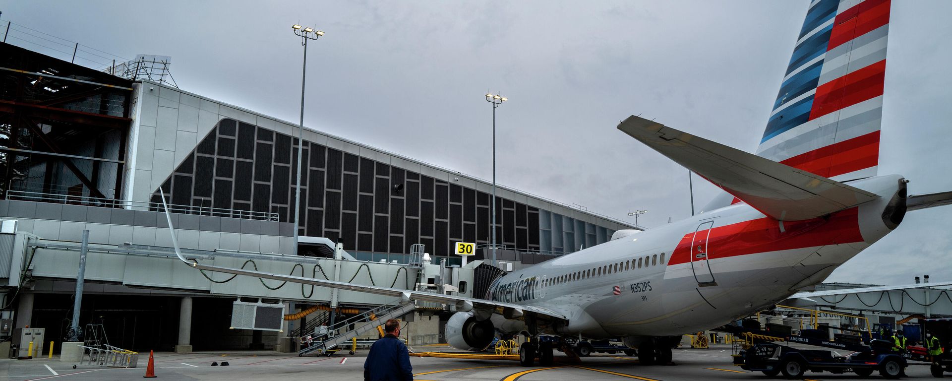 Christopher Rhoads, Manager of Airport Operations/Aviation at LaGuardia Airport in New York, stands near an American Airlines passenger jet being served at gate 30, Wednesday, March 24, 2021, near newer construction at the airport, part of a multi-year, multi-billion dollar project that will modernize almost the entirety of the airport's departure and arrival terminals. Christopher Rhoads, Manager of Airport Operations/Aviation at LaGuardia Airport in New York, stands near an American Airlines passenger jet being served at gate 30, Wednesday, March 24, 2021, near newer construction at the airport, part of a multi-year, multi-billion dollar project that will modernize almost the entirety of the airport's departure and arrival terminals. - Sputnik International, 1920, 09.10.2021