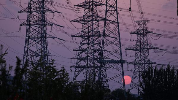The sun sets behind electricity power pylons in Beijing on September 28, 2021 - Sputnik International