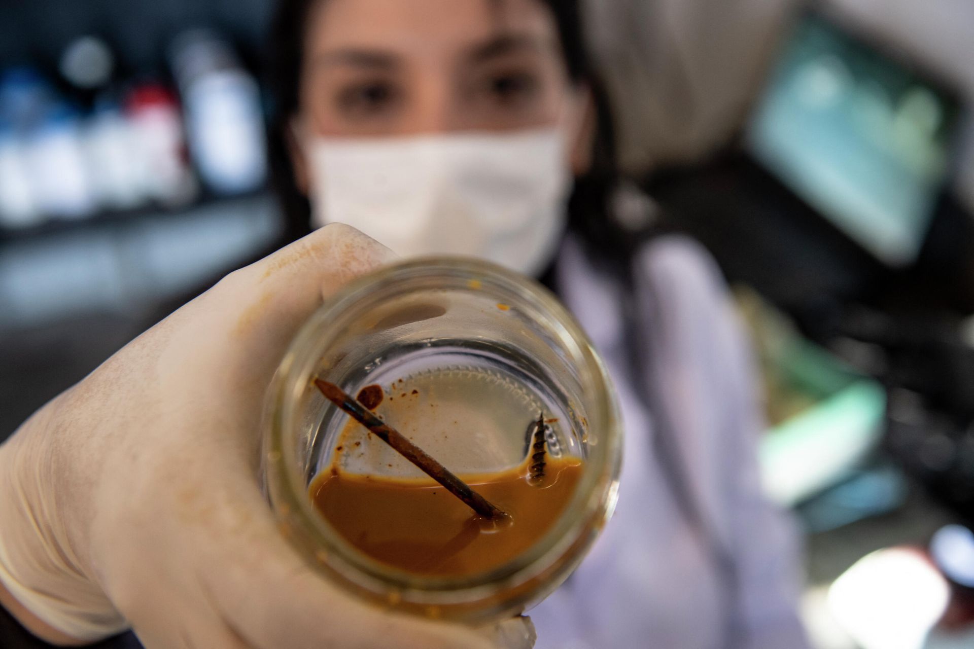 Chilean biotechnologist Nadac Reales shows a nail and screw inside a jar with metal-eater bacteria in her laboratory at a mining site in Antofagasta, Chile - Sputnik International, 1920, 10.10.2021