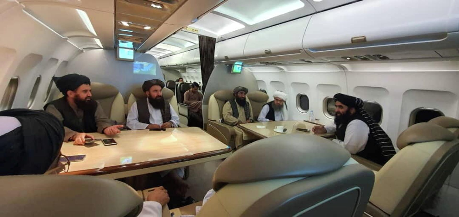 Taliban delegates are seated in a plane in an unidentified location, in this handout photo uploaded to social media on October 9, 2021. - Sputnik International, 1920, 11.10.2021