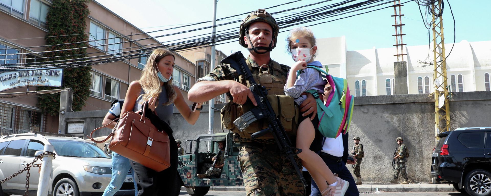 An army soldier carries a schoolchild as civilians flee after gunfire erupted at a site near a protest that was getting underway against Judge Tarek Bitar, who is investigating last year's port explosion, in Beirut, Lebanon October 14, 2021 - Sputnik International, 1920, 14.10.2021