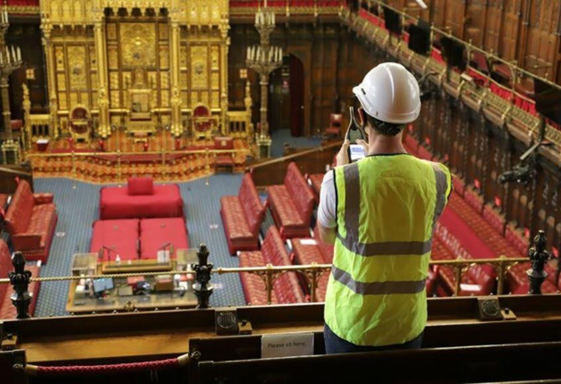A workman taking measurements in the House of Lords' chamber of the Palace of Westminster A workman taking measurements in the House of Lords' chamber of the Palace of Westminster - Sputnik International, 1920, 15.10.2021