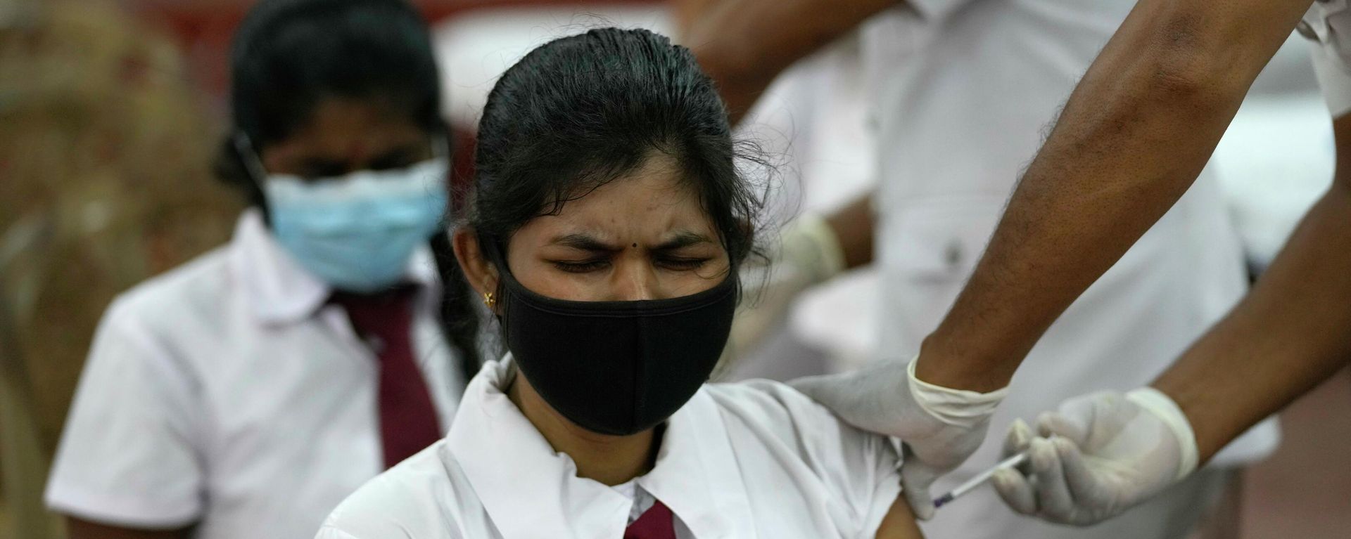 A Sri Lankan school student receives a COVID-19 vaccine in Colombo, Sri Lanka, Friday, Oct. 15, 2021. Sri Lanka is vaccinating 18- and 19-year-olds against the coronavirus as it expands the shots to students. After beginning with older people, Sri Lanka has now vaccinated 57% of its 22 million population. A Sri Lankan school student receives a COVID-19 vaccine in Colombo, Sri Lanka, Friday, Oct. 15, 2021. Sri Lanka is vaccinating 18- and 19-year-olds against the coronavirus as it expands the shots to students. After beginning with older people, Sri Lanka has now vaccinated 57% of its 22 million population. - Sputnik International, 1920, 15.10.2021