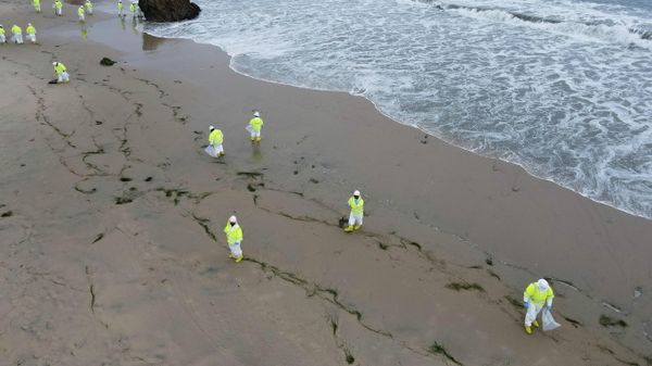 Workers rake up globs of crude oil after more than 3,000 barrels (126,000 gallons) of crude oil leaked from a ruptured pipeline into the Pacific Ocean in Corona Del Mar State Beach, Newport Beach, California, U.S. October 7, 2021. - Sputnik International