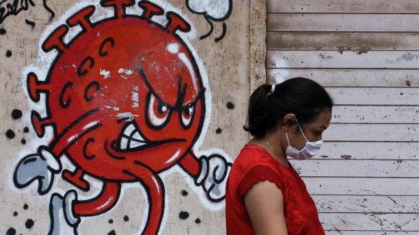 A woman walks past a coronavirus-themed graffiti, amidst the spread of the COVID-19 pandemic, on a street in Mumbai, India, October 12, 2021. - Sputnik International