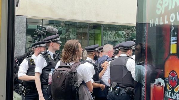 Britain's Housing Secretary Michael Gove walks while surrounded by police officers and protesters, in London - Sputnik International