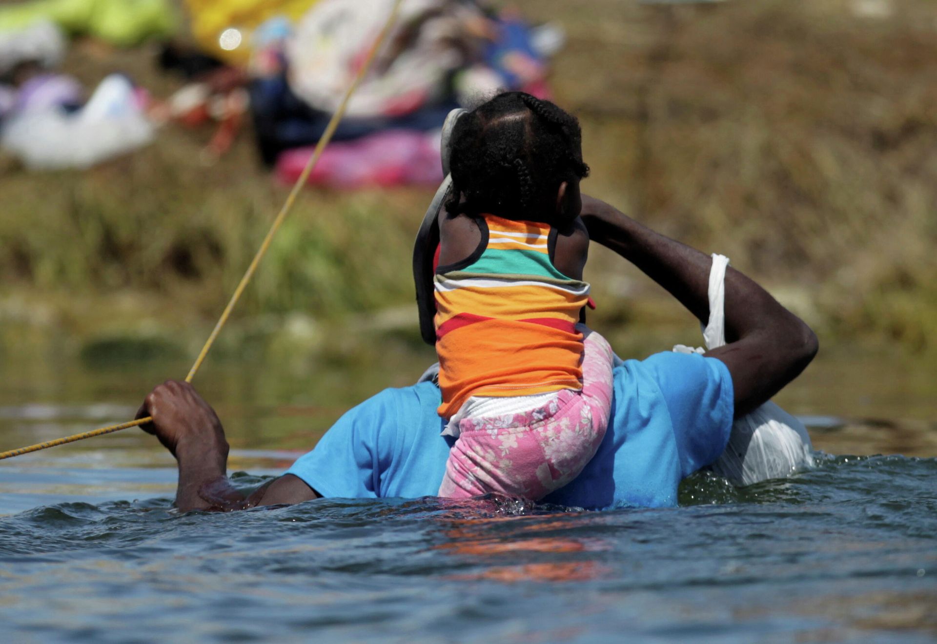 A migrant with a child seeking refuge in the U.S. wades through the Rio Grande from Ciudad Acuna, Mexico toward Del Rio, Texas, U.S., in Ciudad Acuna, Mexico September 22, 2021. - Sputnik International, 1920, 19.10.2021