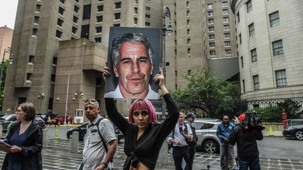 A member of a protest group called Hot Mess holds up a sign of Jeffrey Epstein in front of the Metropolitan Correction Center on July 8, 2019 in New York City. - Sputnik International