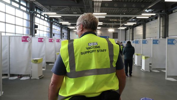 A member of the NHS vaccine support staff looks on as residents wait to receive the Oxford/AstraZeneca Covid-19 vaccine from a member of the Hampshire Fire and Rescue Service at a temporary vaccination centre set up at Basingstoke Fire Station, Hampshire, south England, as crews continue to take 999 emergency calls - Sputnik International