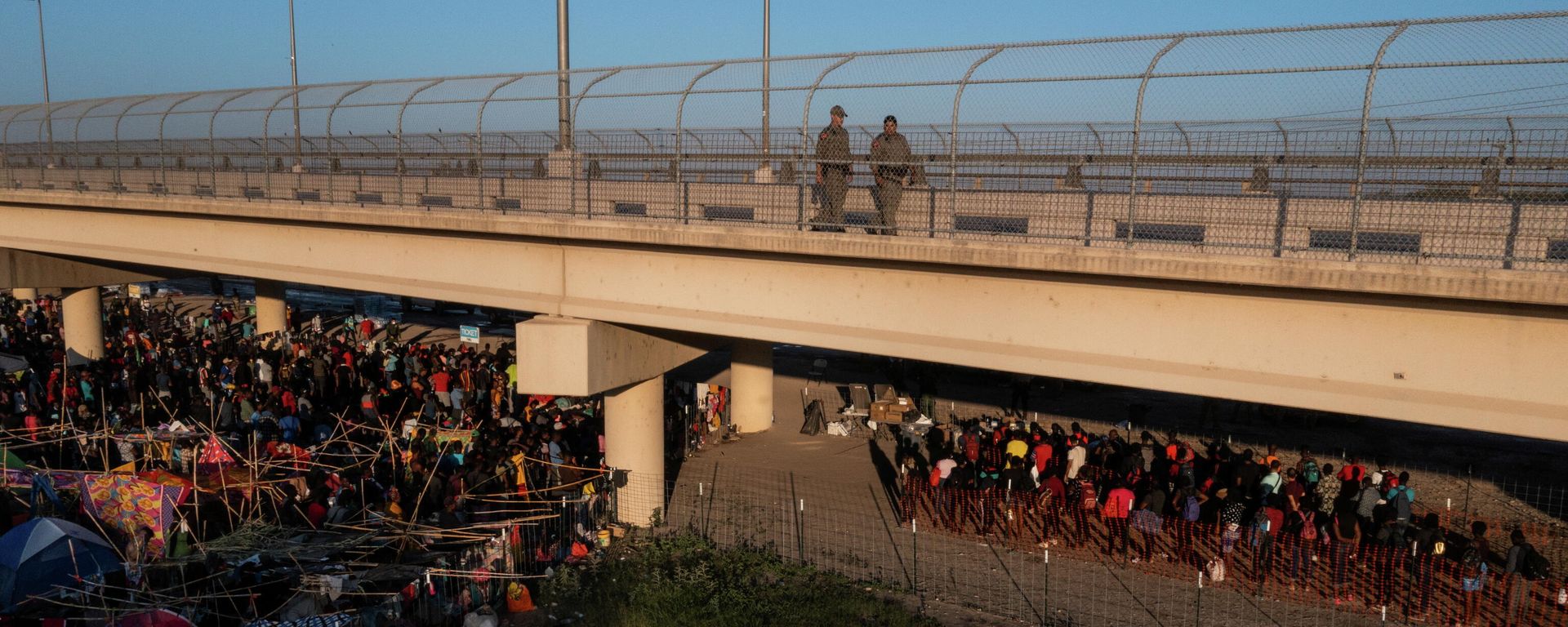 Texas State Troopers walk across the International Bridge as some migrants line up to depart on a bus as thousands of others await to be processed after crossing the Rio Grande river into the U.S. from Ciudad Acuna in Del Rio, Texas, U.S. September 20, 2021 Texas State Troopers walk across the International Bridge as some migrants line up to depart on a bus as thousands of others await to be processed after crossing the Rio Grande river into the U.S. from Ciudad Acuna in Del Rio, Texas, U.S. September 20, 2021 - Sputnik International, 1920, 20.10.2021