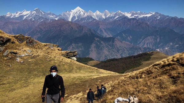 People wearing face masks trek up to Khalia top as snow clad Himalayan ranges of Panchchuli mountains are seen behind near Munsiyari in the Indian state of Uttarakhand, Thursday, Oct. 29, 2020. - Sputnik International
