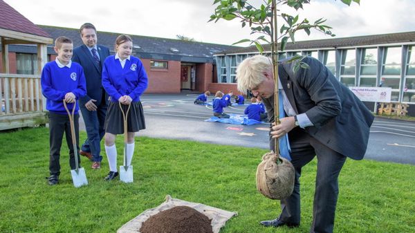 Britain's Prime Minister Boris Johnson plants a tree during a visit to Crumlin Integrated Primary School in County Antrim - Sputnik International